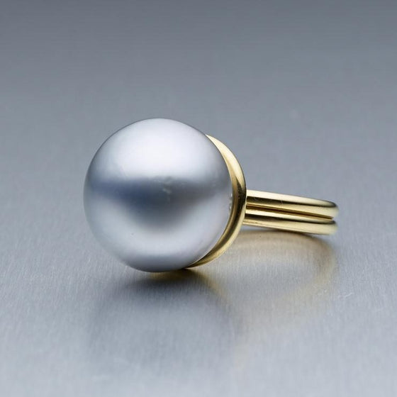 A BUNDA "Bundova" ring in 18ct yellow gold, featuring a button shaped Cultured Tahitian pearl.  The pearl is approximately 16.30mm in diameter, is platinum in colour with a clean skin and an excellent lustre.  Total weight: 13.14 grams