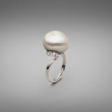  A BUNDA 'Lyra' Cultured Tahitian Pearl and Diamond ring made in 18 carat white gold, set with a button shaped pearl of clean skin and excellent lustre, platinum in colour with green tones. Round brilliant diamonds are thread-set in ribbon style setting beneath the pearl swirling to a plain shank in 18ct white gold.  Dimensions of pearl: 15.40mm  Weight of diamonds: 20 =0.38ct, F Colour, VS Clarity  Total weight of Ring: 9.46g