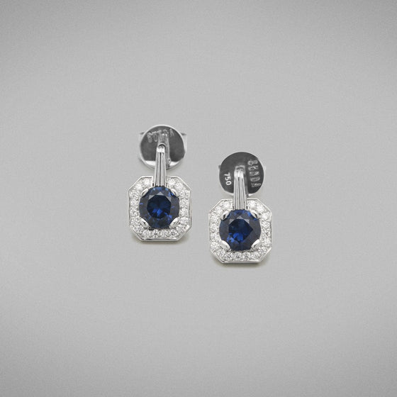 Each earring is set with a 0.80ct round brilliant sapphire from Rubyvale, Queensland in a platinum four claw setting that is surrounded by thread-set round brilliant diamonds to the head.  Characteristics of Sapphires: 2 = 1.61cts  Total diamond weight = 0.20ct, F Colour, VS Clarity