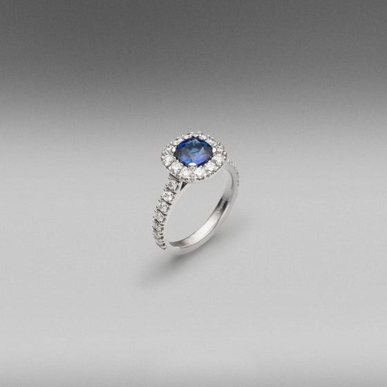 'Valentin' Sapphire and diamond ring in 18 carat white gold, featuring a cushion cut Ceylon Sapphire, weighing 1.17ct, surrounded with castle set round brilliant cut diamonds set in the halo and on the shoulders.  Total diamond weight = 1.16ct.