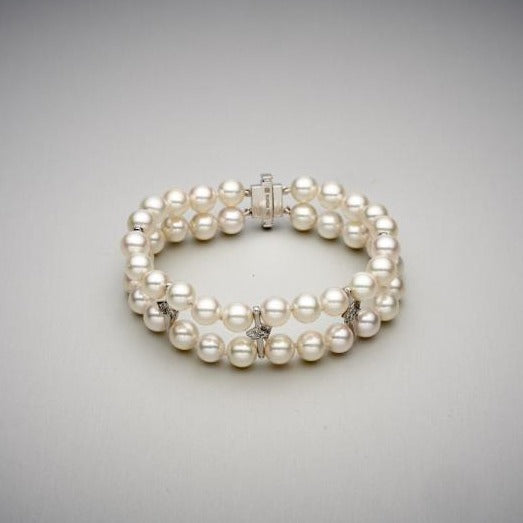 A BUNDA 'Apus' double strand bracelet, featuring Akoya pearls, strung knotted with a high polished 18ct white gold diamond set rectangular clasp, and high polished 18ct white gold diamond set spacers.  The 44 pearls are round in shape, white in colour, have excellent lustre and clean skins and range in size from 7.00 - 7.45mm  Characteristics of Additional Diamonds: 36 = 0.50ct, F Colour / VS Clarity  Clasp is stamped 'BUNDA'  Total Weight: 31.76 grams