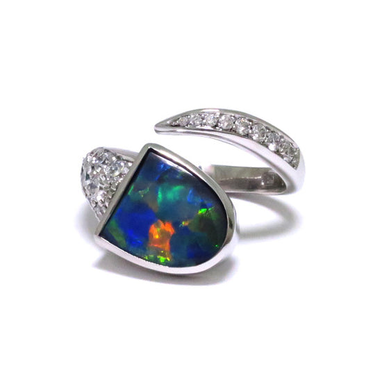 A Superb Australian Black Opal, with excellent play of colour, bezel set in 18ct white gold with pave and thread set diamonds in a wrap setting.  The Opal weighs 1.56ct, features colours of blue, green and strong reds and originates from Lightning Ridge, Australia.  Characteristics of additional diamonds: 20 = 0.68ct, F colour, VS clarity.  Total weight of Ring: 8.80 grams